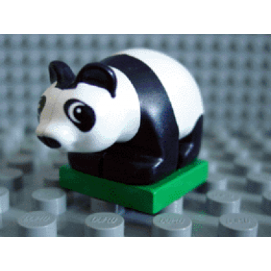 white duplo panda baby cub on green base eyes looking left