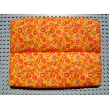 orange scala cloth mattress with middle seam with multicolored circles pattern